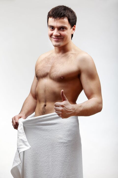 The man in a towel is satisfied with the increase in size of his penis.